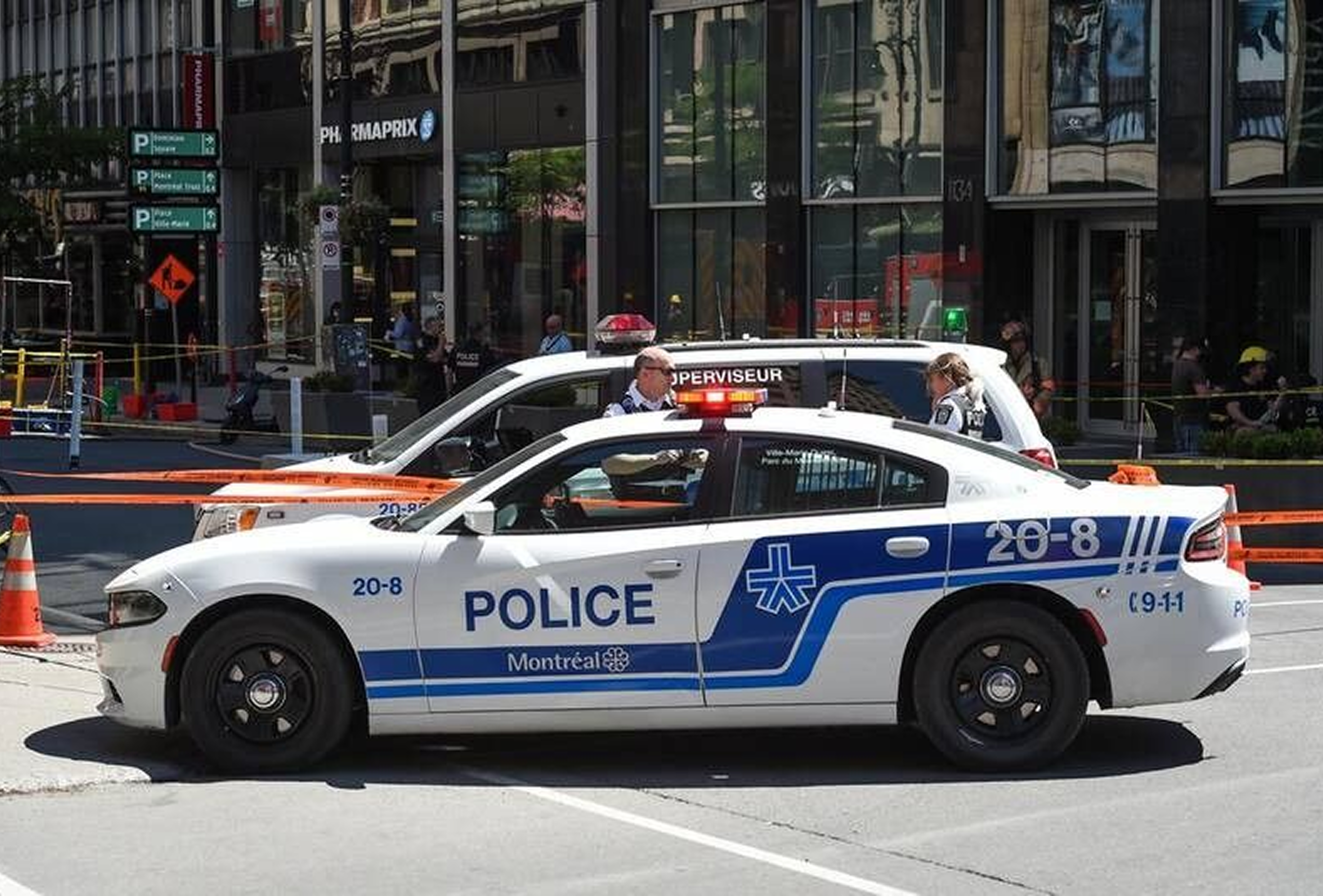 Voiture de police devant une rue barrée
